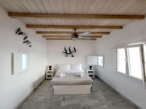 a bedroom with a bed and a ceiling fan at Ricardo by the sea in Parikia
