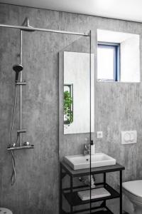 ein Bad mit einem Waschbecken und einem Spiegel in der Unterkunft The New Post Office in Vestmannaeyjar