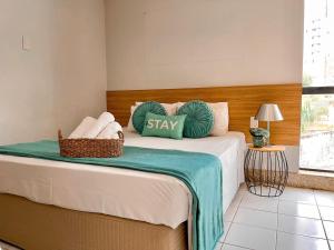 Schlafzimmer mit einem Bett mit grünen und weißen Kissen in der Unterkunft STAY Sun Square in Goiânia