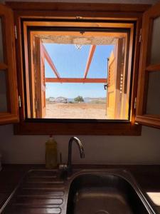 a kitchen sink with a view of the desert through a window at Beach Villa Lipsi Island Getaway in Lipsoi