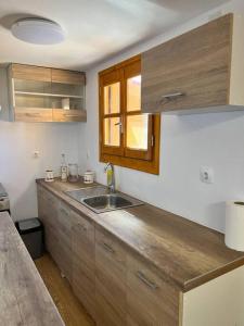 una cucina con lavandino e piano di lavoro in legno di Beach Villa Lipsi Island Getaway a Lisso (Lipsoi)