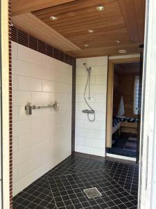 a shower in a bathroom with a tile floor at Villa Tourula in Jyväskylä