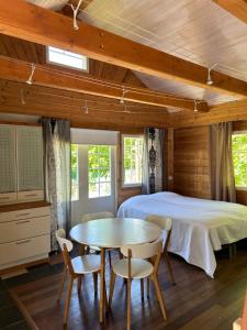 Villa Tourula في يوفاسكولا: غرفة نوم بسرير وطاولة وكراسي