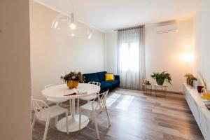 sala de estar con mesa blanca y sofá azul en Sacrati 39, en Ferrara
