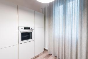 cocina blanca con microondas y ventana en Sacrati 39, en Ferrara