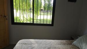 a bedroom with a bed and a large window at Tierra Clara Chacras in Ciudad Lujan de Cuyo