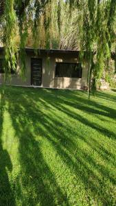 a grass yard with a building in the background at Tierra Clara Chacras in Ciudad Lujan de Cuyo