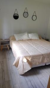 a bed in a bedroom with two lights on the wall at Tierra Clara Chacras in Ciudad Lujan de Cuyo