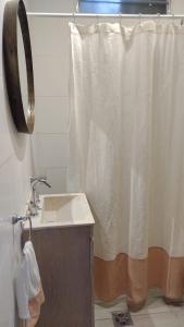 a bathroom with a sink and a shower curtain at Tierra Clara Chacras in Ciudad Lujan de Cuyo