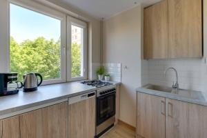 a kitchen with a stove top oven next to a window at Motława 1 by Grand Apartments in Gdańsk