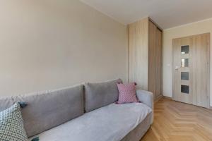 a living room with a gray couch with two pillows at Motława 1 by Grand Apartments in Gdańsk