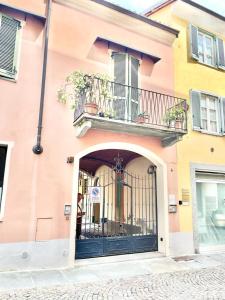 a pink building with a gate and a balcony at ALLOGGIO MAIA in Biella