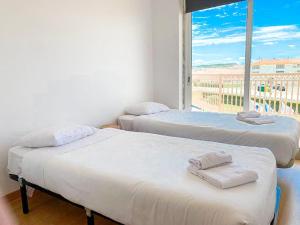 two beds in a room with a view of a balcony at HI Santa Cruz - Pousada de Juventude in Santa Cruz +18 photos