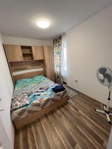 a bedroom with a bed and a desk and a fan at Apartament Madalina cu 2 dormitoare si vedere spre Dunare in Corabia