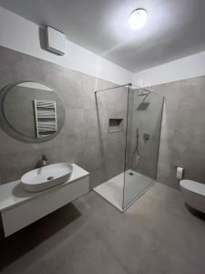 a bathroom with a sink and a shower with a mirror at Villa La Domazet in Podstrana
