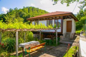 una pequeña casa con un banco en un jardín en Holiday Home Lyubovo en Gabrovo