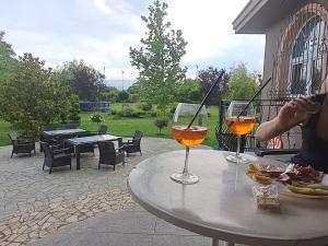 una persona seduta a un tavolo con due bicchieri di vino di Green Villa Rodna a Skopje