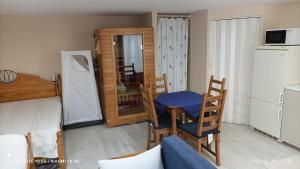 a room with a table and chairs and a kitchen at Fejesvölgy Stúdióapartman in Veszprém