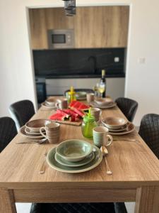 una mesa de madera con platos y utensilios. en Villa La Domazet, en Podstrana