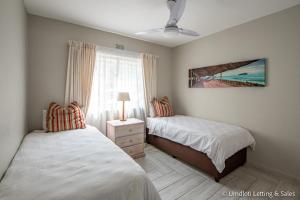 - une chambre avec 2 lits et une fenêtre dans l'établissement Isikulu 27B, à Umdloti