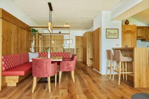 un soggiorno con divano rosso e tavolo di Appartementhaus Dachsteinblick mit Indoorpool und Sauna a Bad Goisern