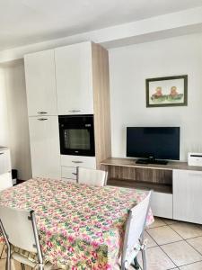 a room with a table with chairs and a television at Alloggio MAIA centro Biella in Biella