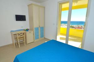 a bedroom with a bed and a desk with a view of the ocean at B&B Lu Cantoru in Marina di Pescoluse