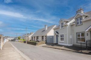 a row of white houses on a street at Kilkee Townhouse in Kilkee