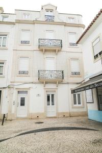 een groot wit gebouw met een balkon bij Casa Ribeiro in Nazaré