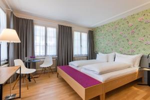 una camera d'albergo con letto, tavolo e sedie di Linde Heiden Swiss Quality Hotel a Heiden