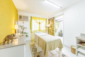 ein Schlafzimmer mit einem Bett und einer gelben Wand in der Unterkunft Tri Hotel Le Chateau in Gramado