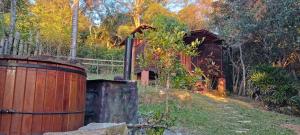 un tonneau en bois assis à côté d'une maison en bois dans l'établissement Vila do Mago, à Itamonte