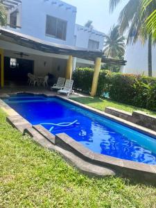 una piscina blu di fronte a una casa di Casa Villas del Pacifico Puerto San José a Puerto San José