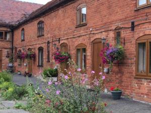 a brick building with flowers in front of it at Irelands Farm Cottages in Birmingham