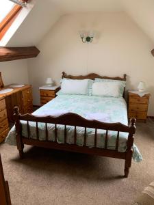 a bedroom with a bed with two dressers and two lamps at Irelands Farm Cottages in Birmingham