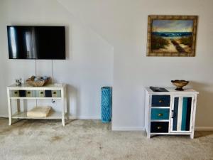 a living room with a tv on a wall at 215 C2 GP-The Treehouse in Coffeyville