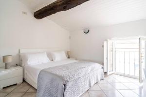 a white bedroom with a bed and a window at Chess House in Azzano Mella