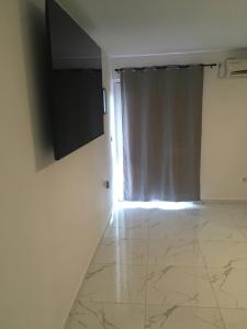 a living room with a television and a tiled floor at Sunshine apartments in Karlobag