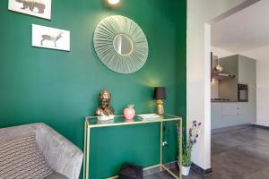 um quarto com uma parede verde com uma mesa com um espelho em Together In Salento em Morciano di Leuca
