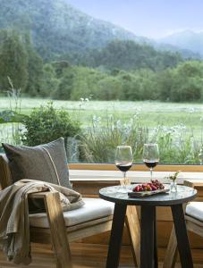 two glasses of wine on a table in front of a window at Futangue Hotel & Spa in Lago Ranco