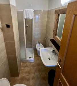 uma casa de banho com um lavatório, um chuveiro e um WC. em B&B CHALET NICOLUSSI em Trento
