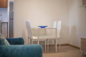 a dining room table with white chairs and a bowl on it at La Corte by HelloElba in Portoferraio