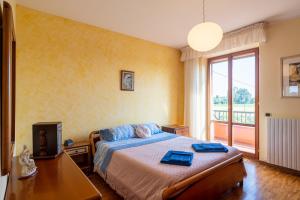 sypialnia z łóżkiem i dużym oknem w obiekcie Casa Vittoria w mieście Potenza Picena