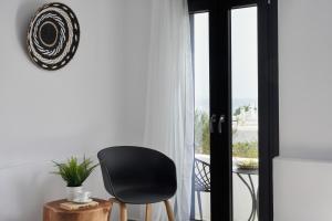 a black chair sitting in front of a window at The Thermia Suites in Kithnos