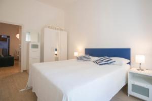 een slaapkamer met een groot wit bed met 2 kussens bij La Corte by HelloElba in Portoferraio