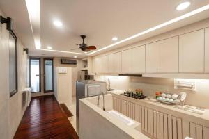 a large kitchen with white cabinets and a ceiling fan at Villa Family R7 The Height Khaoyai 1BR byน้องมังคุด in Ban Huai Sok Noi