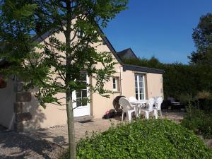 a table and chairs in front of a house at La Tentonniere in Saint-Michel-de-Montjoie