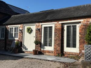 a brick house with white doors and windows at The Wren in Blackfordby