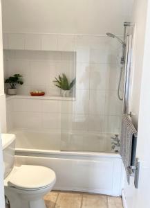 a bathroom with a white tub and a toilet at The Wren in Blackfordby