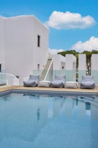 uma piscina com almofadas ao lado de um edifício em The Thermia Suites em Kythnos